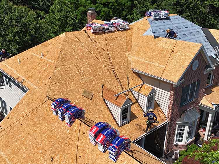 Roofers completing a full roof replacement.