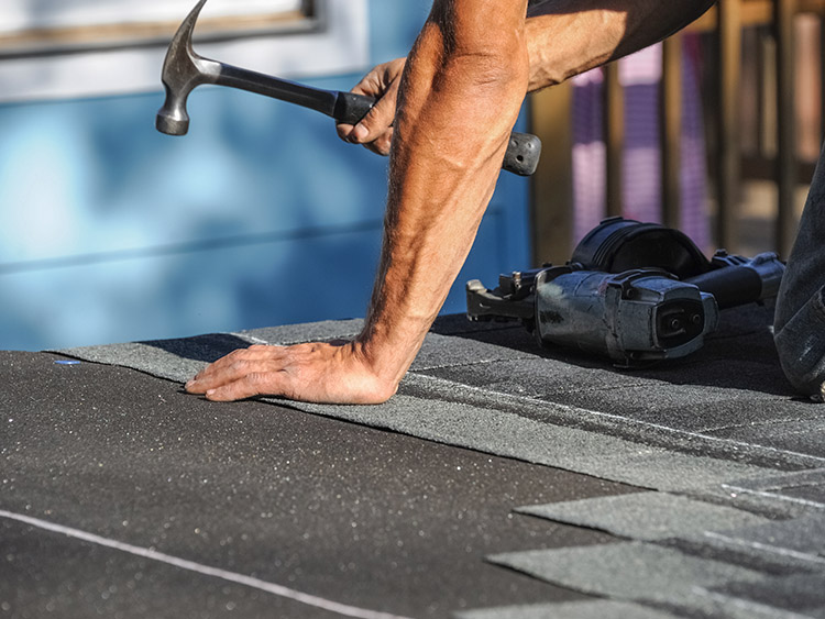 Roofer replacing missing shingles.