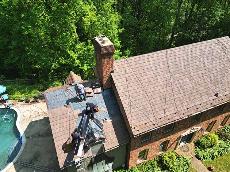 AC Matthews roofers installing synthetic slate roofing.