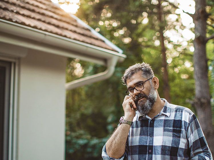 Homeowner outside of home placing a call.
