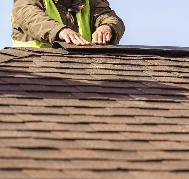 Roofer inspecting shingle roof.