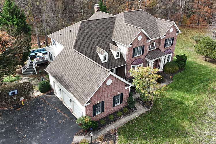 Completed shingle roof installation on modern residential home.