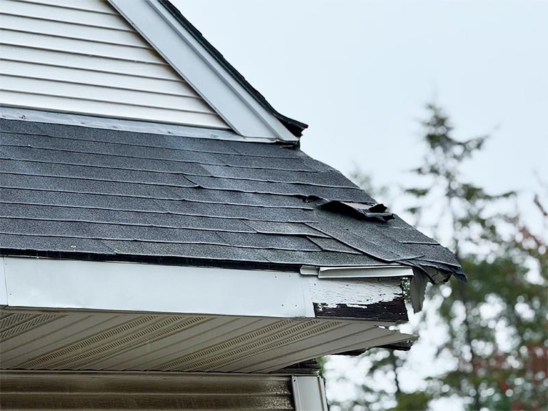 Damaged roofing at corner of home.