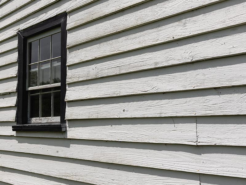 Worn white siding on a residential home.